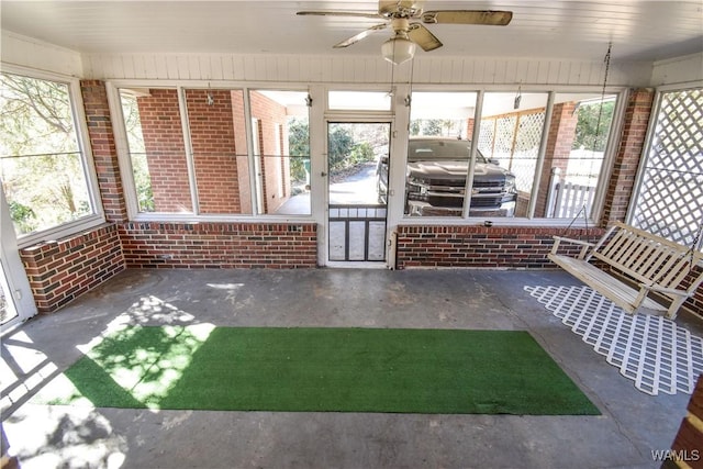 unfurnished sunroom featuring plenty of natural light and a ceiling fan