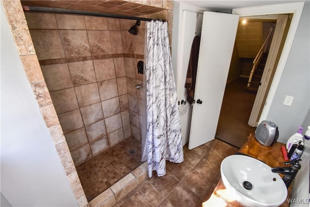 bathroom with a stall shower and a sink