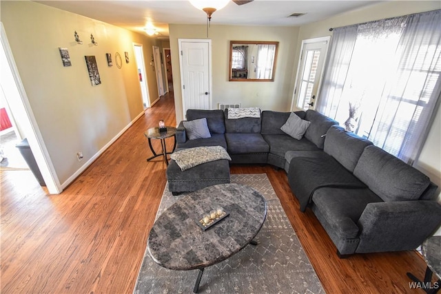 living area featuring visible vents, baseboards, and wood finished floors