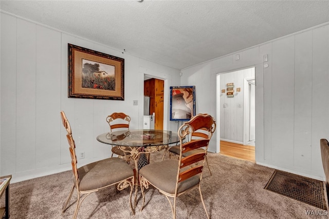 dining space with carpet flooring and a textured ceiling