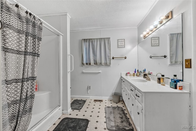 bathroom with a textured ceiling, vanity, walk in shower, and crown molding