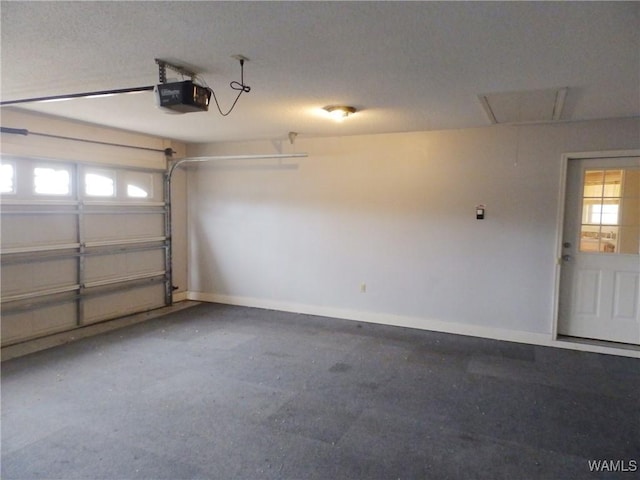 garage featuring a garage door opener and baseboards