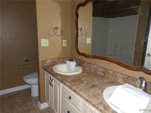 bathroom with toilet, tile patterned floors, and vanity