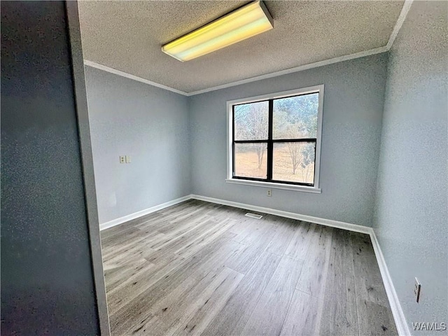 spare room with crown molding, light hardwood / wood-style floors, and a textured ceiling