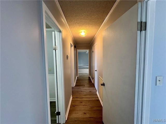 hall featuring wood-type flooring, a textured ceiling, and ornamental molding