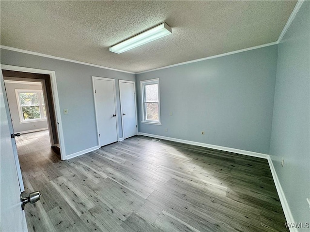 unfurnished bedroom with light hardwood / wood-style flooring, a textured ceiling, and ornamental molding