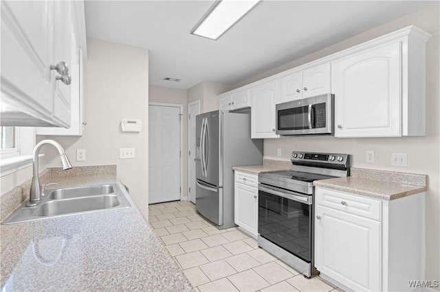 kitchen with light countertops, white cabinetry, a sink, and appliances with stainless steel finishes