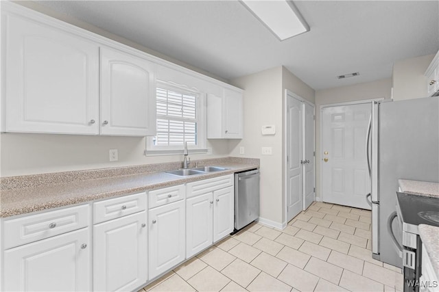 kitchen featuring stainless steel appliances, visible vents, white cabinets, and a sink