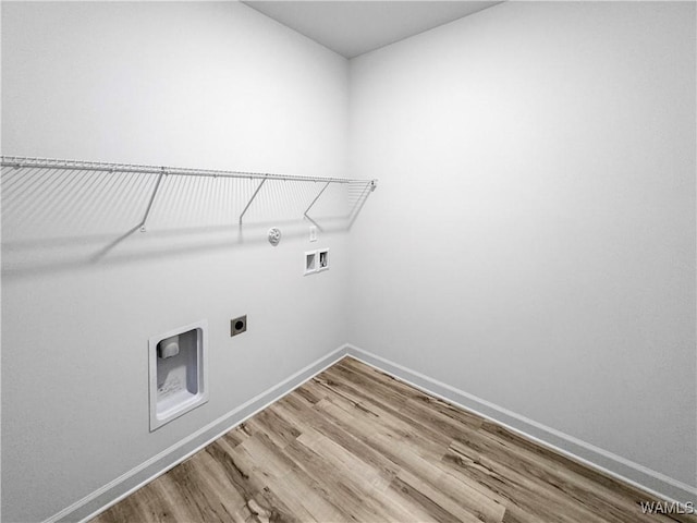 laundry area featuring laundry area, hookup for a washing machine, electric dryer hookup, wood finished floors, and baseboards