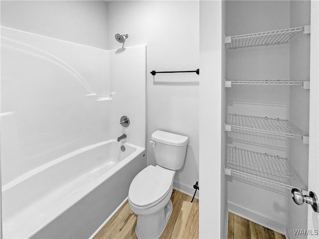 full bathroom featuring  shower combination, baseboards, toilet, and wood finished floors