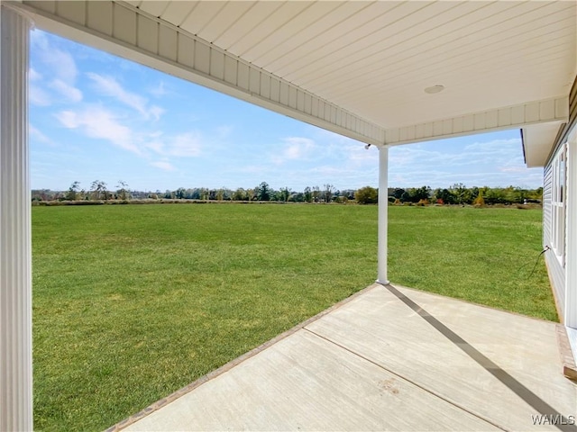 view of yard with a rural view and a patio area