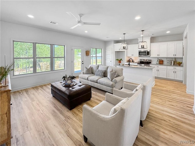 living area with visible vents, baseboards, a ceiling fan, light wood-type flooring, and recessed lighting