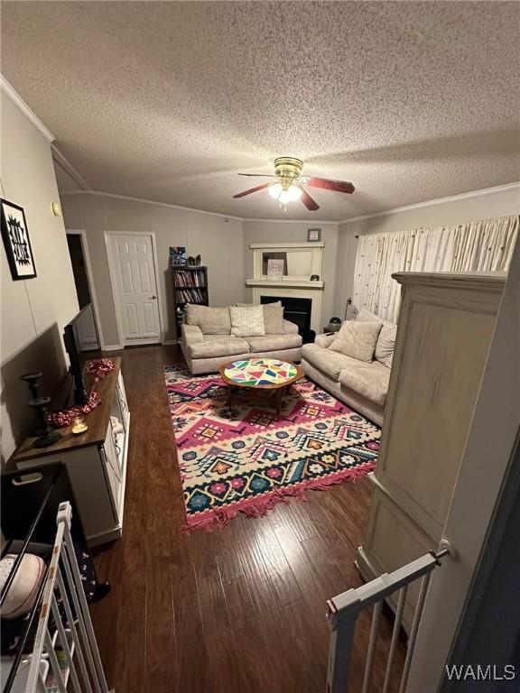 living room featuring crown molding, a textured ceiling, ceiling fan, and dark hardwood / wood-style flooring