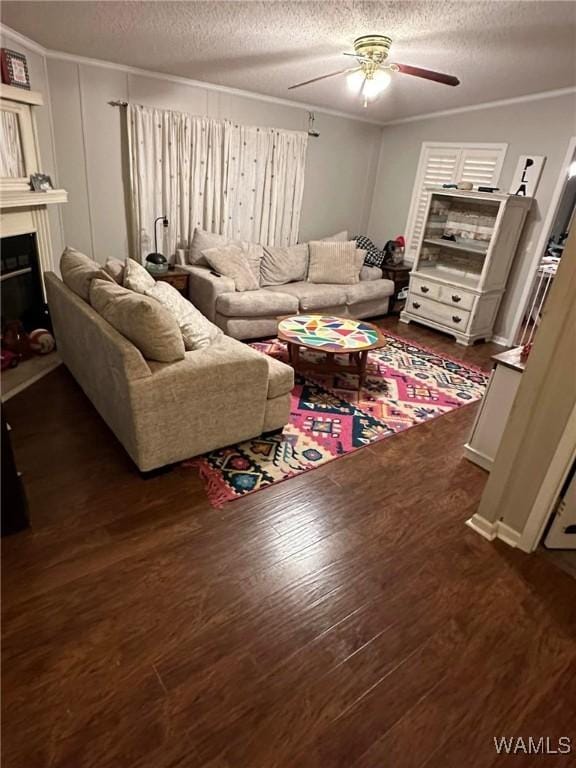 living room with dark hardwood / wood-style flooring, a textured ceiling, ornamental molding, and ceiling fan