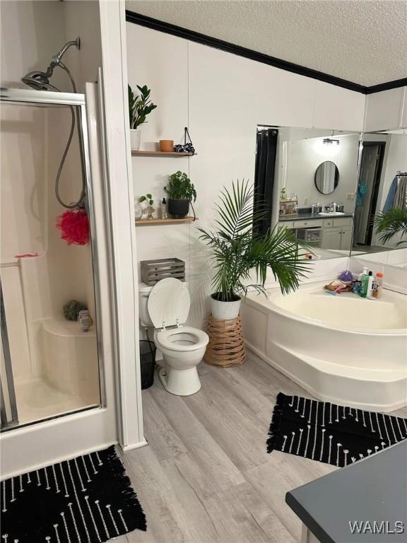 bathroom with hardwood / wood-style flooring, toilet, a textured ceiling, and a shower with shower door