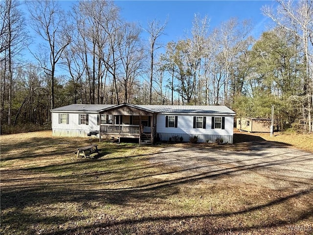 manufactured / mobile home with a porch and a front lawn