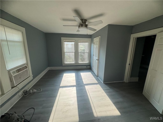 unfurnished bedroom with dark wood-type flooring, cooling unit, a ceiling fan, and baseboards