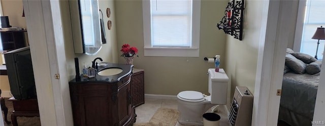 bathroom with tile patterned floors, vanity, toilet, and heating unit