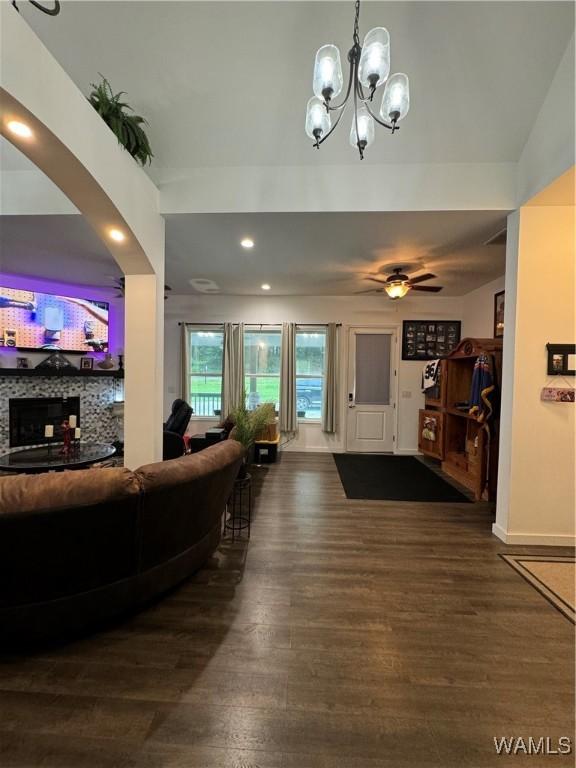 living room with ceiling fan with notable chandelier and wood finished floors