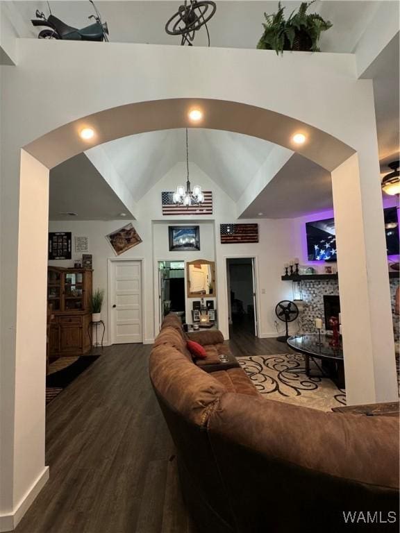 living room featuring high vaulted ceiling, arched walkways, a chandelier, and wood finished floors