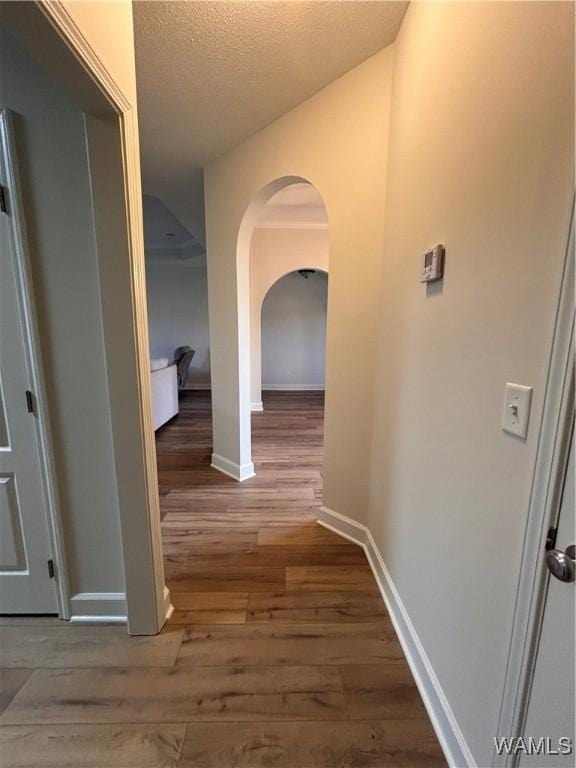 5203 Bristolwood Cir, Northport, AL 35475 - corridor featuring wood finished floors, a textured ceiling, and arched walkways