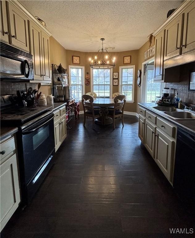 5203 Bristolwood Cir, Northport, AL 35475 - kitchen featuring black appliances, a chandelier, dark countertops, a textured ceiling, and healthy amount of natural light
