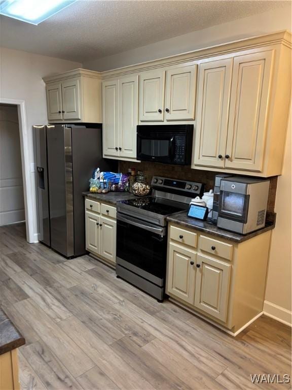 5203 Bristolwood Cir, Northport, AL 35475 - kitchen featuring appliances with stainless steel finishes, cream cabinets, light wood-type flooring, and dark countertops