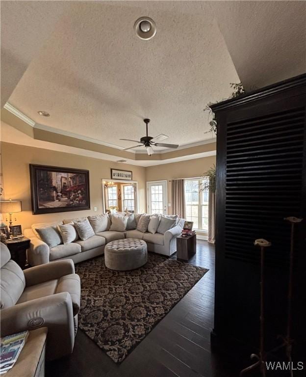 5203 Bristolwood Cir, Northport, AL 35475 - living area with a textured ceiling, a ceiling fan, a tray ceiling, dark wood-style floors, and crown molding
