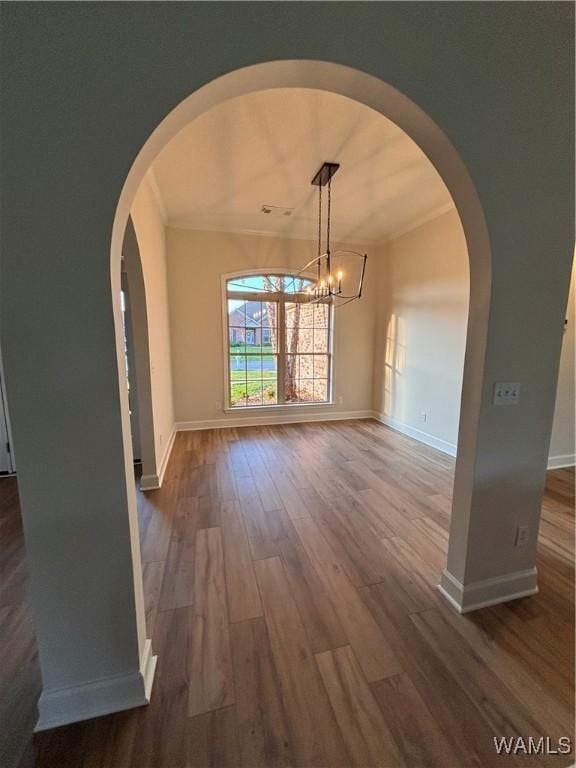 5203 Bristolwood Cir, Northport, AL 35475 - unfurnished dining area with dark wood-style floors, a chandelier, ornamental molding, and arched walkways