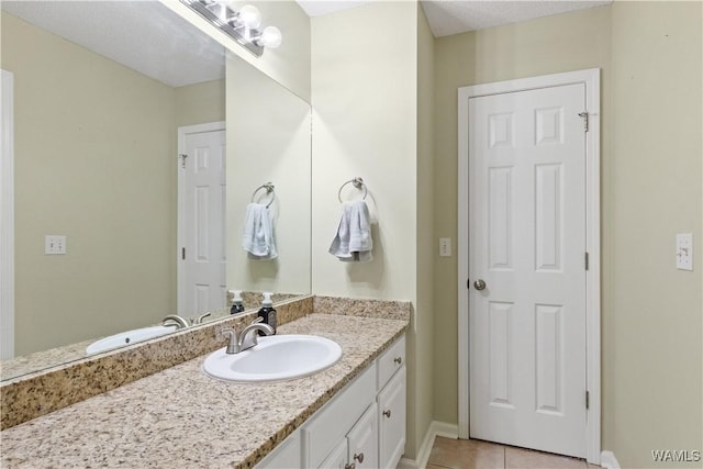 bathroom featuring vanity, tile patterned floors, and baseboards