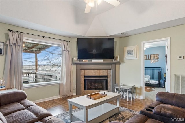 living room with wood finished floors, visible vents, and ceiling fan