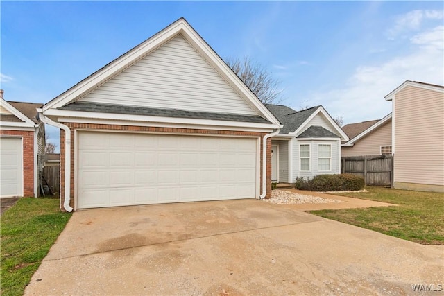 view of front of house with brick siding, fence, a garage, and roof with shingles