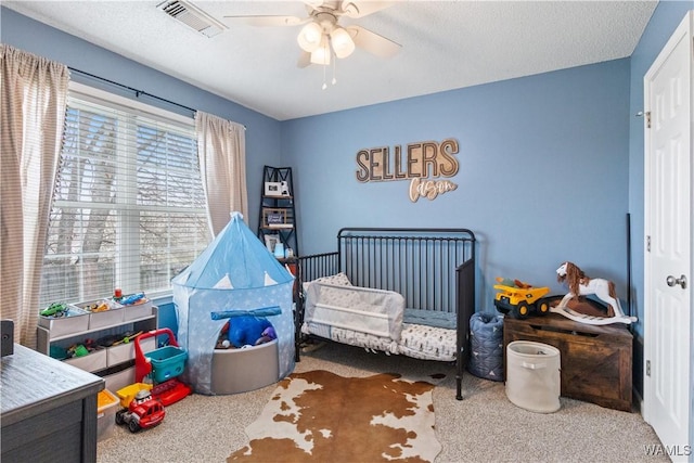 bedroom with visible vents, a textured ceiling, ceiling fan, and carpet flooring