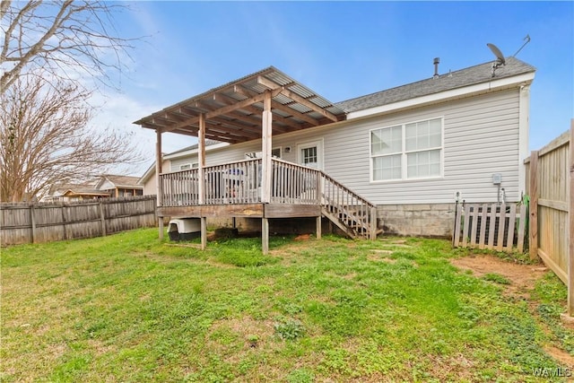 rear view of house featuring a yard, a wooden deck, and a fenced backyard