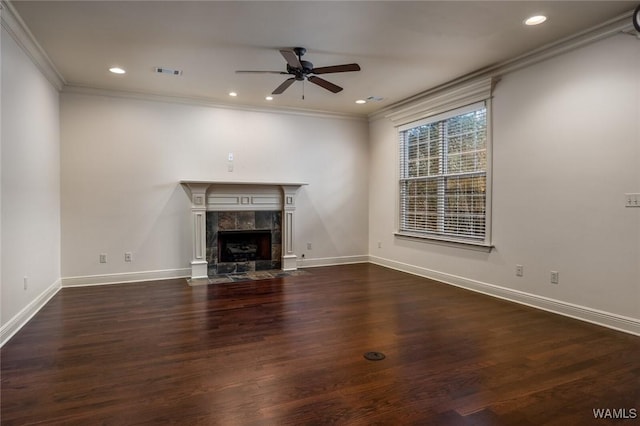 unfurnished living room with ceiling fan, crown molding, dark hardwood / wood-style floors, and a tiled fireplace