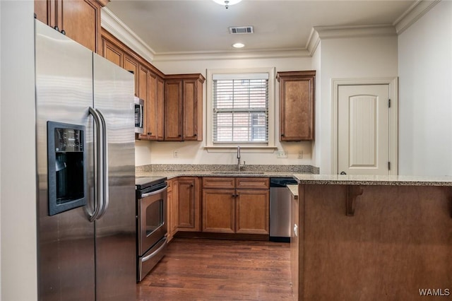 kitchen with appliances with stainless steel finishes, sink, crown molding, dark hardwood / wood-style flooring, and light stone countertops