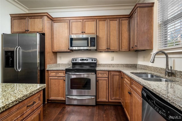 kitchen with sink, light stone counters, dark wood-type flooring, stainless steel appliances, and ornamental molding