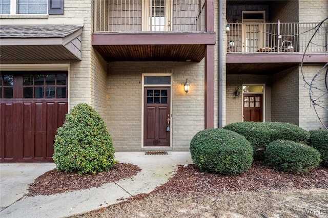 entrance to property featuring a garage and a balcony