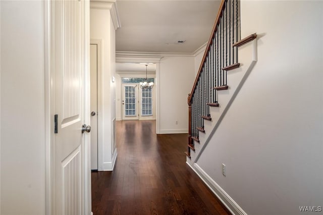 hallway with crown molding, dark hardwood / wood-style floors, and an inviting chandelier