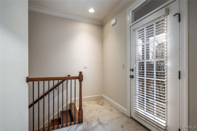 doorway to outside with ornamental molding and light colored carpet