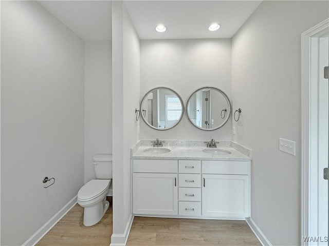 bathroom with hardwood / wood-style flooring, vanity, and toilet