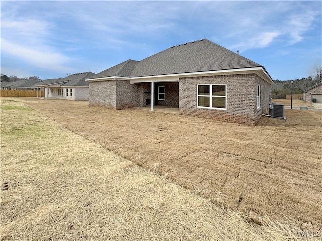 rear view of house featuring cooling unit, a patio, and a lawn