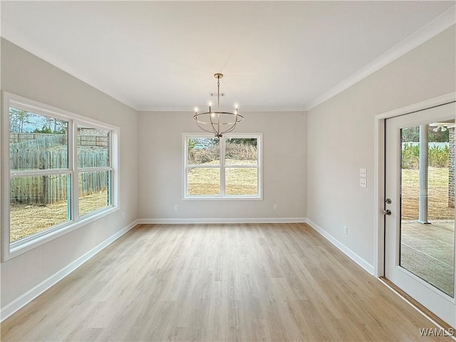 unfurnished dining area with an inviting chandelier, crown molding, and light hardwood / wood-style floors