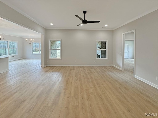 unfurnished room with crown molding, ceiling fan with notable chandelier, and light hardwood / wood-style flooring