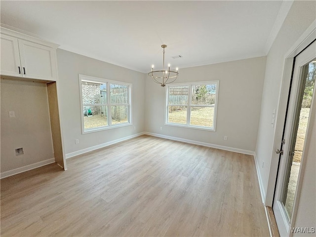 unfurnished dining area with a healthy amount of sunlight, a chandelier, and light hardwood / wood-style floors