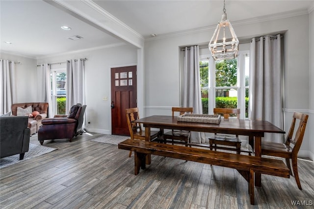 dining room with a notable chandelier, ornamental molding, wood finished floors, and baseboards