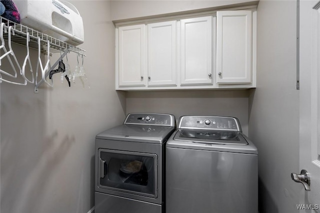 washroom with cabinet space and washer and clothes dryer