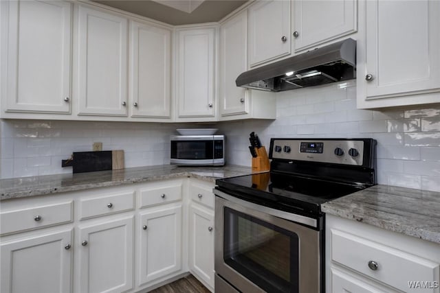 kitchen with under cabinet range hood, appliances with stainless steel finishes, and white cabinets