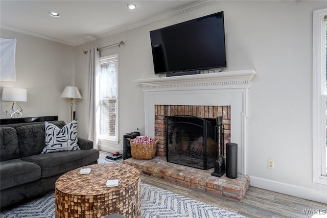 living area with crown molding, a fireplace, recessed lighting, wood finished floors, and baseboards