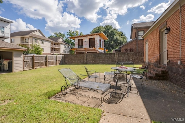 view of yard featuring outdoor dining space, a patio area, a residential view, and a fenced backyard